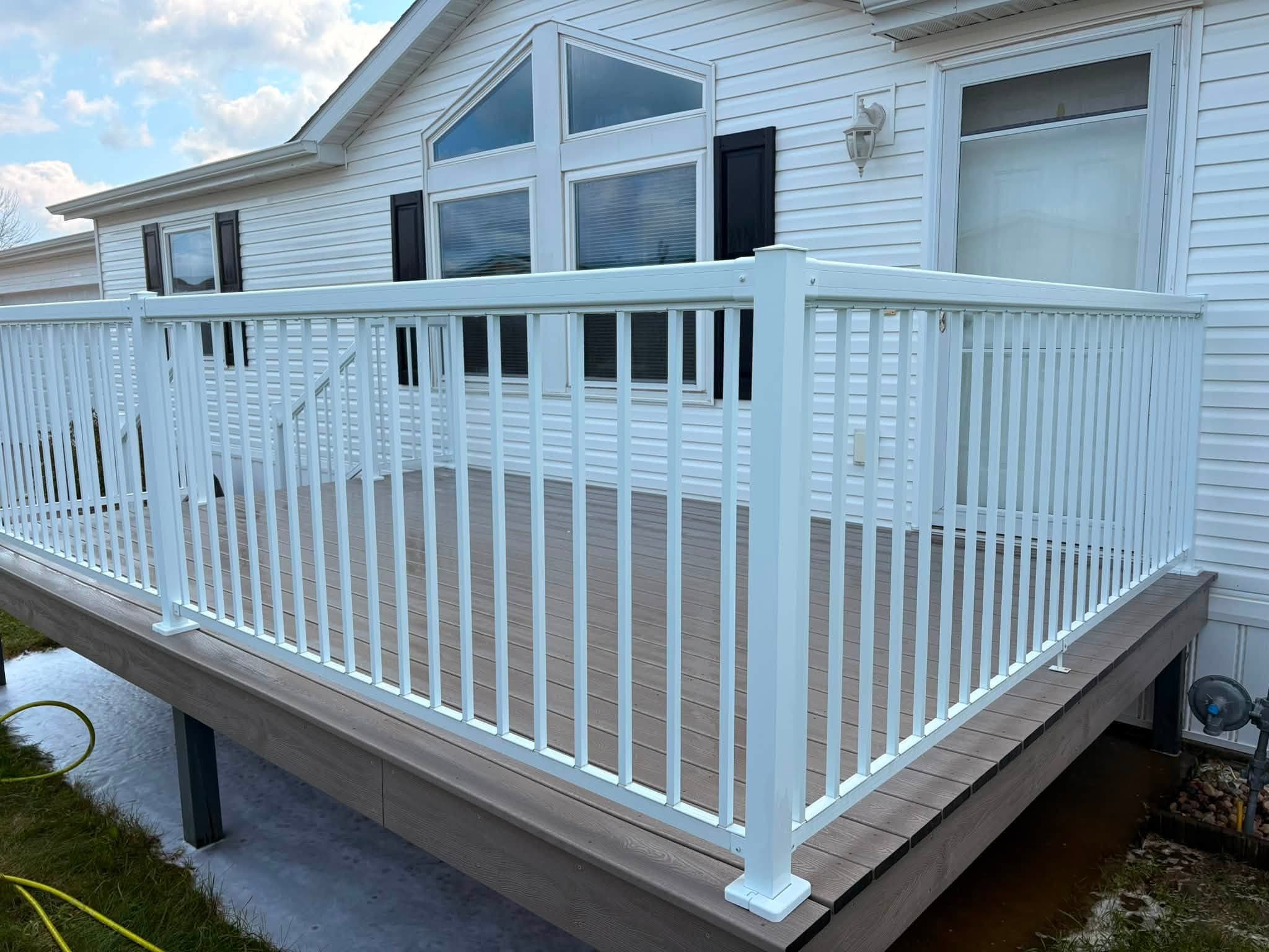 Clean white house siding and deck after exterior cleaning